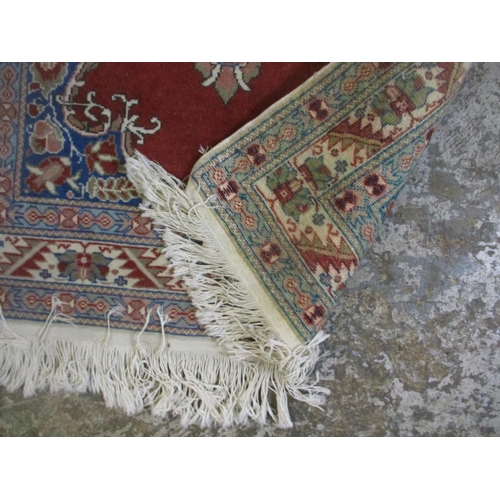 428 - A group of three Persian style rugs to include a red ground rug with central floral motif, triple gu... 