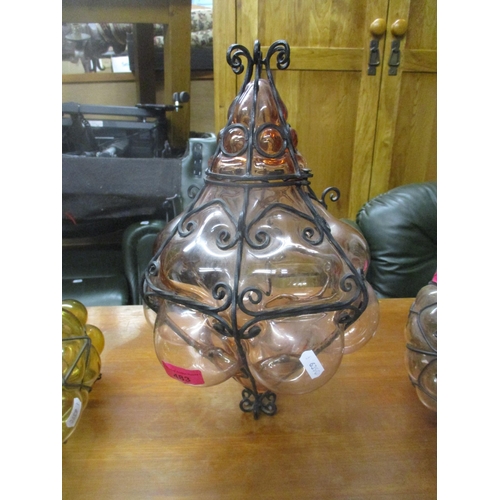 436 - A group of three Italian Seguso style glass and wrought iron caged ceiling pendant lights, one in go... 