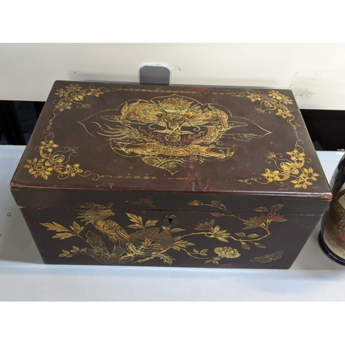 380 - A Chinese lacquered, twin handled box with gilt highlights of a dragon, birds and flowers, together ... 