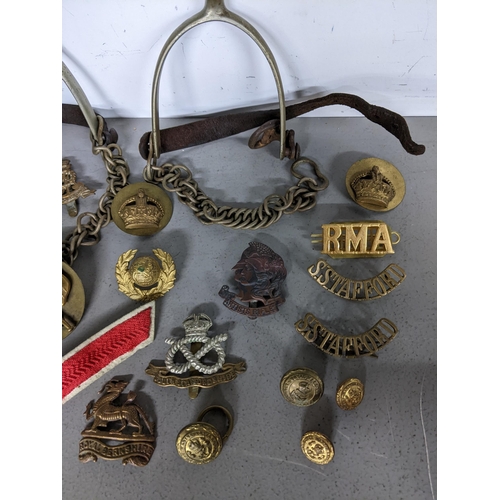 397 - Early 19th century British military items to include a pair of spurs, mixed cap badges to include Ro... 