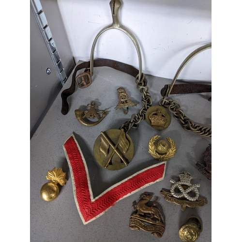 397 - Early 19th century British military items to include a pair of spurs, mixed cap badges to include Ro... 