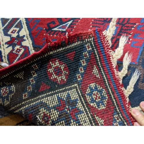 141 - A hand woven Turkish red ground runner having geometric designs and fringed ends, 317 cm x 82 cm RAM