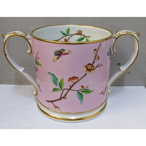 145 - A 19th century Worcester twin-handled loving cup on a pink ground decorated with butterflies and flo... 