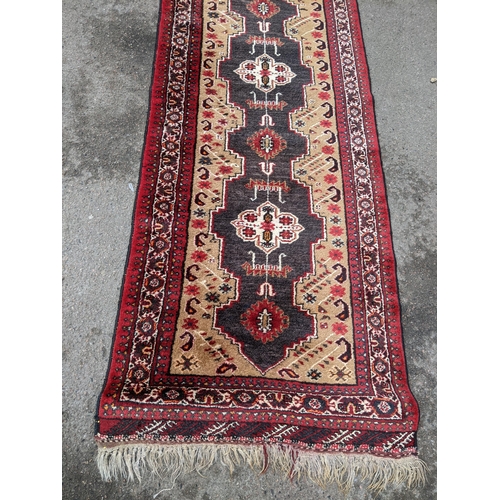 151 - A hand woven Middle Eastern red and beige ground runner having geometric designs and fringed ends, 2... 