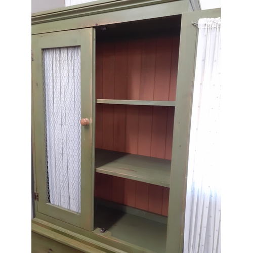 229 - A green painted cabinet in the French style with curtained and metal mesh doors above three long dra... 