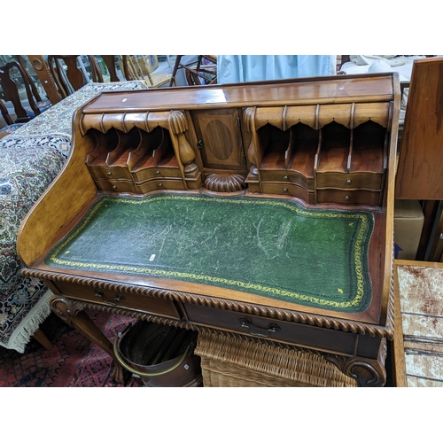 256 - A reproduction mahogany writing desk having fitted pigeonholes with drawers below, green leather scr... 