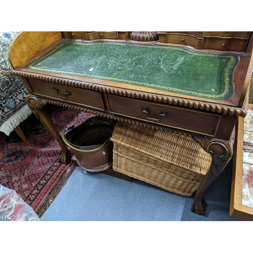 256 - A reproduction mahogany writing desk having fitted pigeonholes with drawers below, green leather scr... 