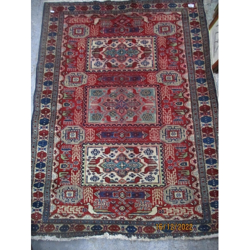 209 - Iranian hand woven red ground rug, three rectangular central panels with stylized birds and geometri... 