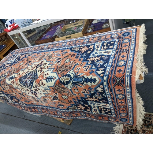 625 - A hand woven Turkish red ground rug with geometric design and tasselled ends Location: LAB