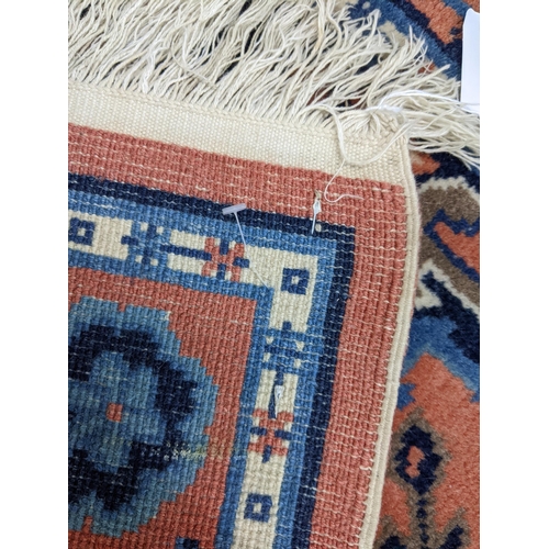 625 - A hand woven Turkish red ground rug with geometric design and tasselled ends Location: LAB