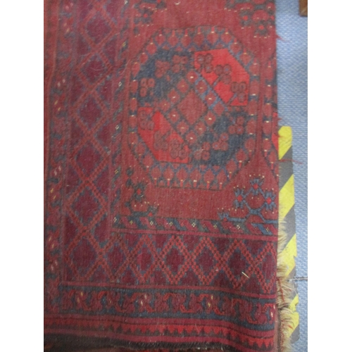 71 - A Persian hand woven red ground rug decorated with elephant gulls, multiguard border and tasselled e... 