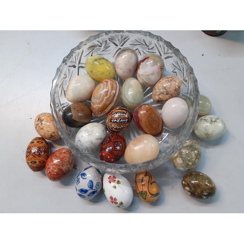 170 - A collection of decorative eggs in onyx, wood and china together with two vintage tins and a white P... 