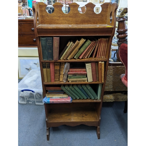 127 - An early 20th century oak five-tier open bookcase containing mixed books to include Sherlock Holmes ... 