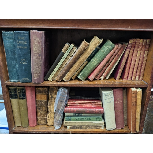 127 - An early 20th century oak five-tier open bookcase containing mixed books to include Sherlock Holmes ... 