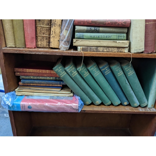 127 - An early 20th century oak five-tier open bookcase containing mixed books to include Sherlock Holmes ... 