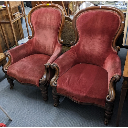 128 - A pair of Victorian mahogany spoon back salon armchairs having scroll shaped arms and turned legs Lo... 