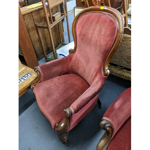 128 - A pair of Victorian mahogany spoon back salon armchairs having scroll shaped arms and turned legs Lo... 