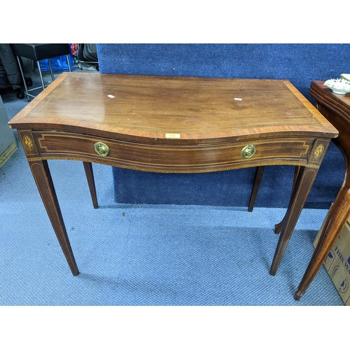 129 - A George III mahogany serpentine fronted side table having parquetry inlaid, single drawer and taper... 