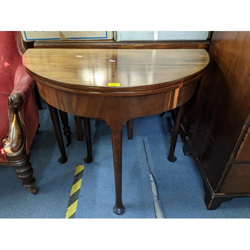 130 - A Georgian mahogany foldover card table having turned legs and pad shaped feet 71cm h x 84cm w Locat... 