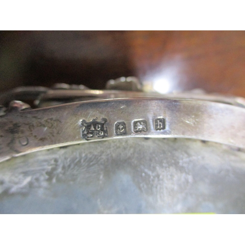 156 - An Edwardian VII silver oval dressing table box, repoussé decorated with winged heads to the lid sur... 