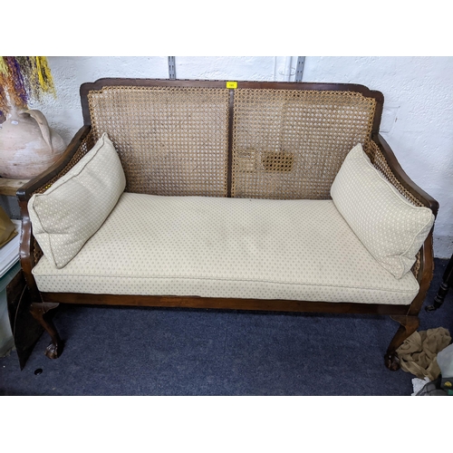 195 - An early 20th century mahogany two seater Berger sofa having sausage and pea moulding and on ball an... 