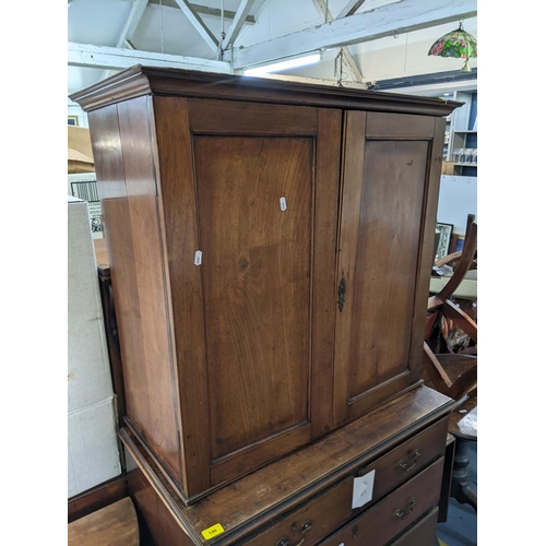 196 - A Georgian mahogany chest of drawers having a matched two-door cabinet to the top with two short and... 