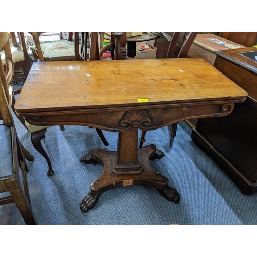 203 - An early 19th century mahogany fold over card table having a green baize, quadrafoil base and on lio... 