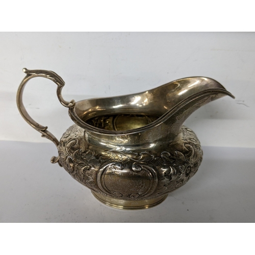35 - A Victorian silver cream jug with embossed floral and C-scrolls hallmarked London 1843, 205.7g Locat... 