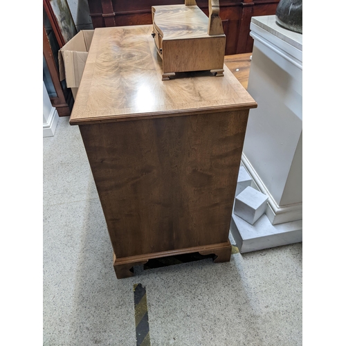 313 - A 20th century walnut desk with seven drawers and a door on bracket feet, and a matching swing mirro... 