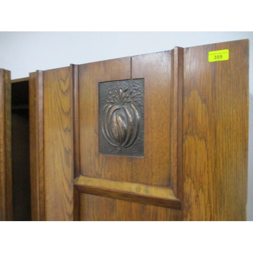 355 - An Arts & Crafts oak wardrobe with twin doors with inset copper plaques, copper handles and escutche... 