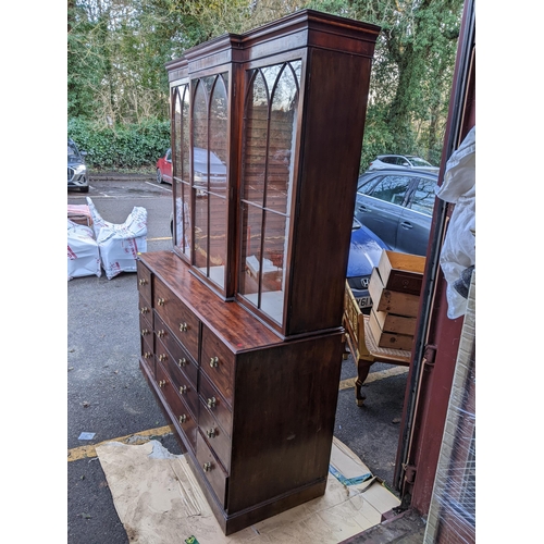 306 - A Regency mahogany secretaire bookcase having a stepped cornice above three glazed doors, pull down ... 