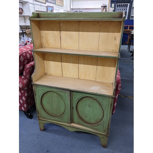 337 - An early/mid 20th century green painted three tier open bookcase with two cupboard doors below 121.5... 