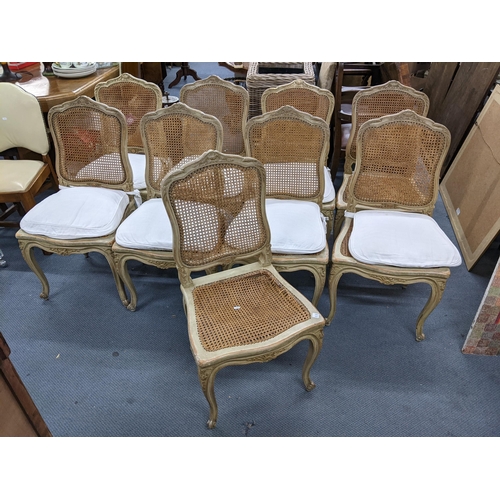 340 - A set of nine French painted dining chairs having cane upholstery, serpentine front and on cabriole ... 