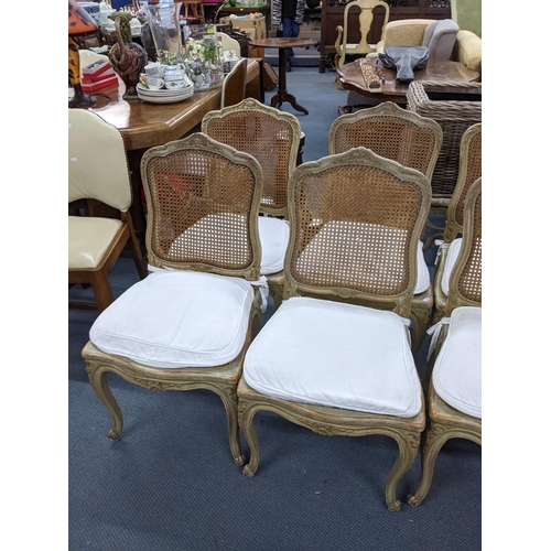 340 - A set of nine French painted dining chairs having cane upholstery, serpentine front and on cabriole ... 