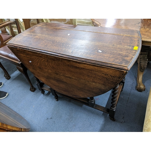 407 - A 1930s oak gateleg table A/F having barley twist supports and on castors 76cm h x 108cm w Location:... 