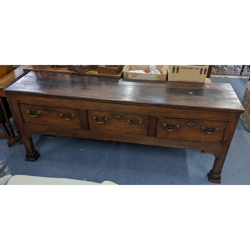 408 - A Georgian oak dresser base having three drawers with brass swan neck handles and on squared cut-dow... 