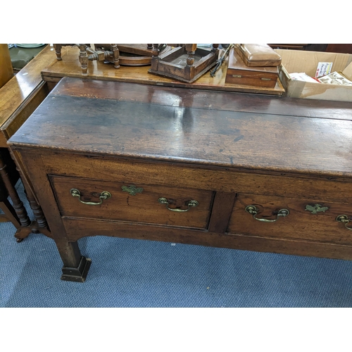 408 - A Georgian oak dresser base having three drawers with brass swan neck handles and on squared cut-dow... 