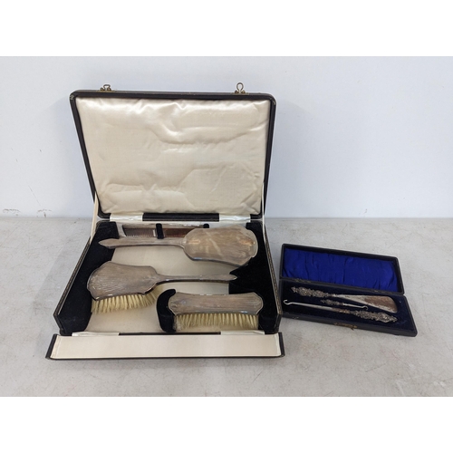 429 - A boxed silver mounted dressing table brushes and comb set, along with a cased set of silver handled... 