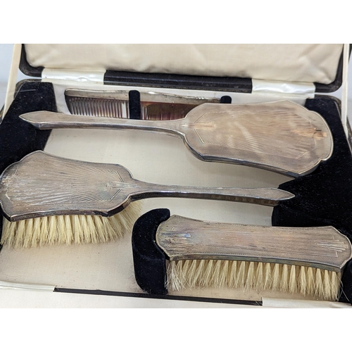 429 - A boxed silver mounted dressing table brushes and comb set, along with a cased set of silver handled... 