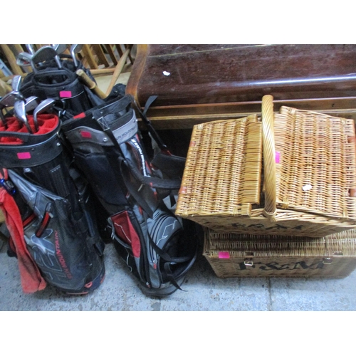 101 - A group of three golf bags containing 13 iron golf clubs, two wicker hampers, and a vintage cloth an... 
