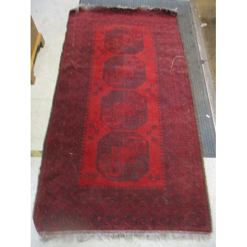 102 - An Afghan handwoven rug, four central elephant gulls on a red ground, triple guard border 205cm x 11... 