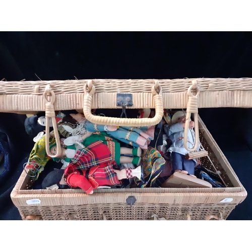 295 - Dolls of the World to include mid 20th century fabric examples, all housed in a small hamper basket ... 