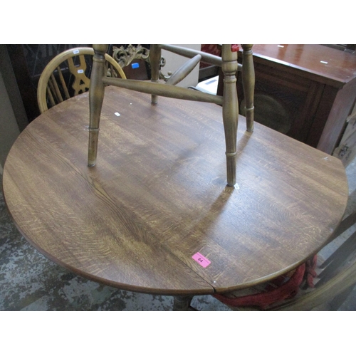 84 - An oak drop flap kitchen/dining table, circular top on turned legs 73cm x 63.5cm (unextended), x 107... 
