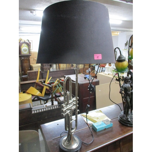 87 - A modern table lamp in the form of a trumpet, mounted on a circular black base, with shade Location:... 