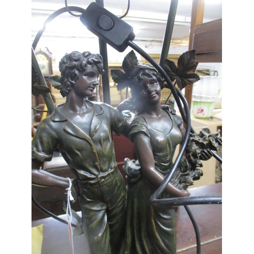88 - A modern composition bronzed resin table lamp in the form of a courting couple holding flowers, moun... 