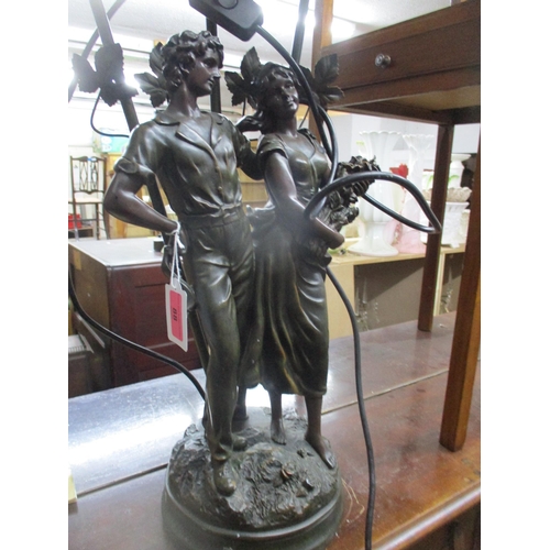 88 - A modern composition bronzed resin table lamp in the form of a courting couple holding flowers, moun... 