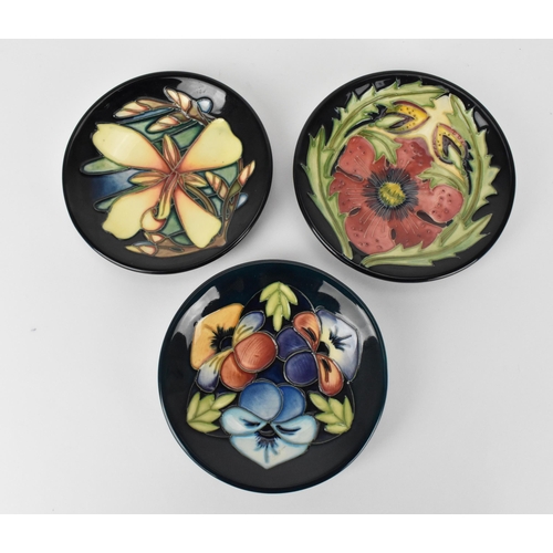 62 - Three Moorcroft pottery pin dishes by various artists, to include Rachel Bishop in the 'Pansies' pat... 