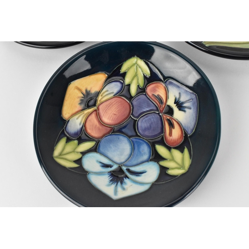 62 - Three Moorcroft pottery pin dishes by various artists, to include Rachel Bishop in the 'Pansies' pat... 