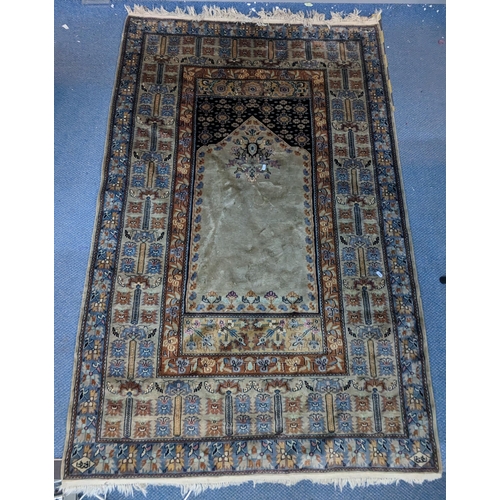 139 - A hand woven green ground Middle Eastern rug A/F having floral design repeating and tasselled ends 1... 