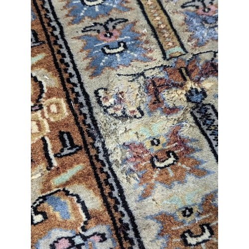 139 - A hand woven green ground Middle Eastern rug A/F having floral design repeating and tasselled ends 1... 